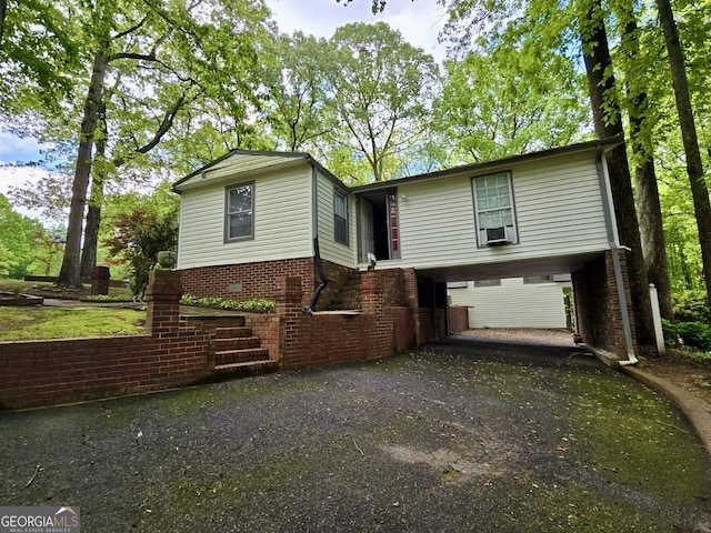view of front of house with brick siding, driveway, and cooling unit