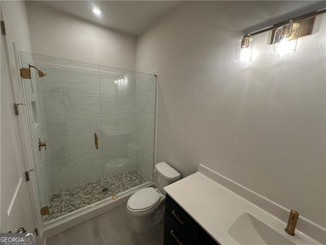 bathroom featuring toilet, a stall shower, tile patterned floors, and vanity