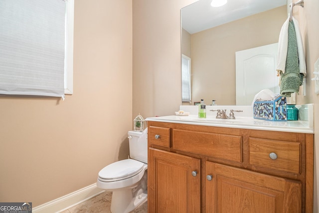 bathroom with vanity, toilet, tile patterned flooring, and baseboards