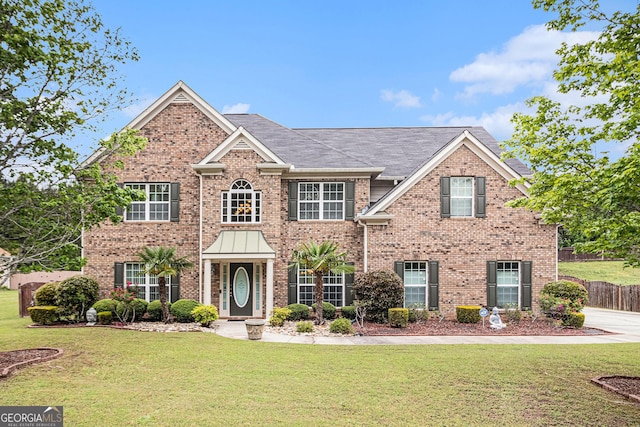 colonial inspired home featuring a front lawn and brick siding
