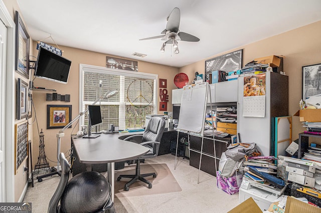 office featuring carpet flooring, visible vents, and ceiling fan