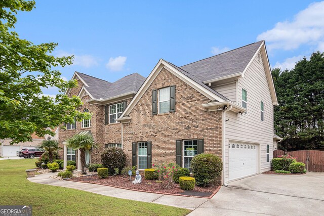 view of front of house featuring driveway, fence, a front lawn, brick siding, and a garage