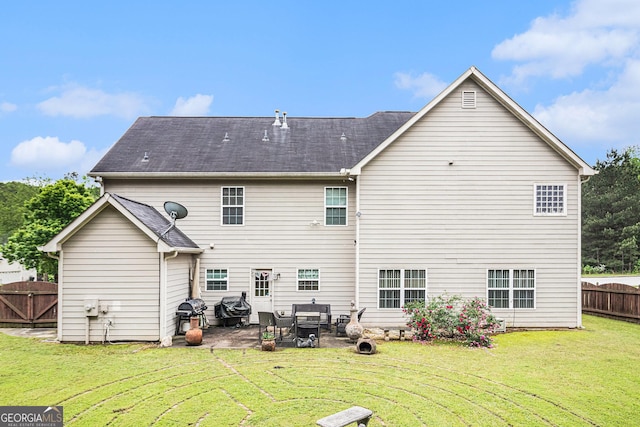 back of property featuring a lawn, fence, and a patio area