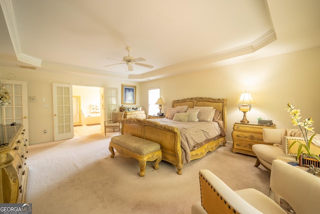 bedroom with a ceiling fan, visible vents, light colored carpet, ornamental molding, and a tray ceiling