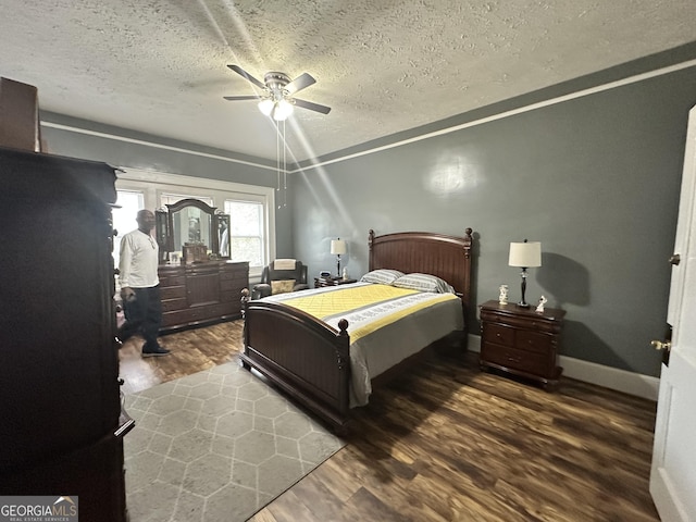 bedroom with baseboards, wood finished floors, a ceiling fan, and a textured ceiling