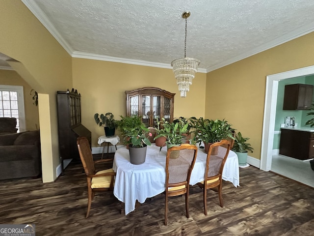 dining area featuring crown molding, a notable chandelier, baseboards, and dark wood finished floors