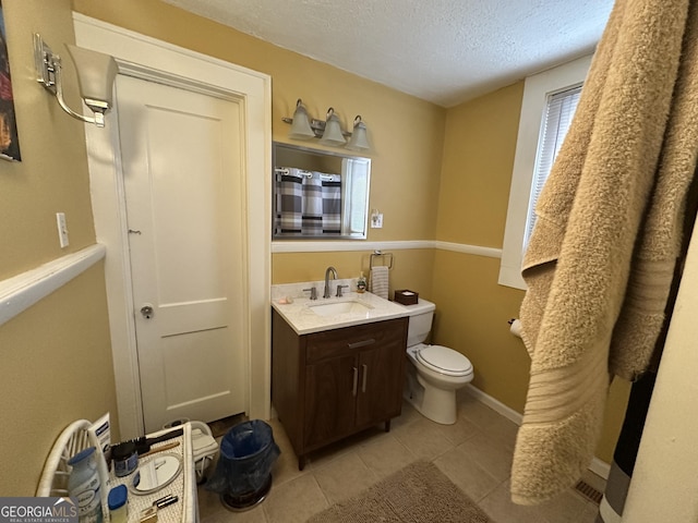 full bath with a textured ceiling, baseboards, toilet, vanity, and tile patterned flooring