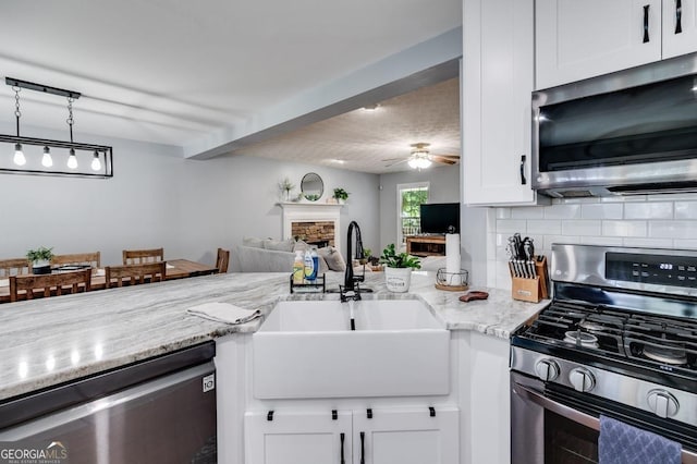 112 Hightower Rd, Hiram, GA 30141 - kitchen with a sink, a fireplace, ceiling fan, white cabinets, and appliances with stainless steel finishes