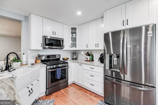112 Hightower Rd, Hiram, GA 30141 - kitchen with light stone countertops, a sink, white cabinetry, and stainless steel appliances