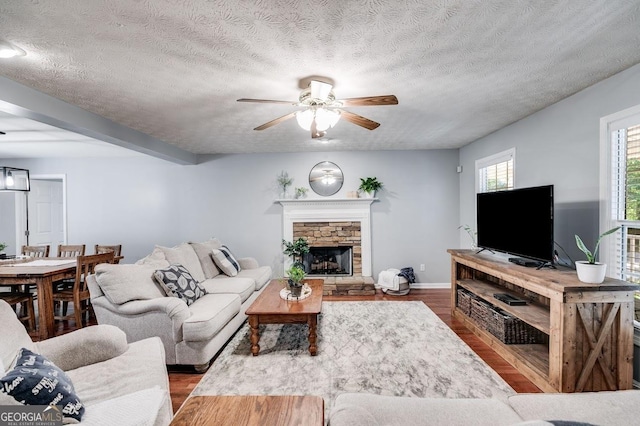 112 Hightower Rd, Hiram, GA 30141 - living room featuring a fireplace, ceiling fan, baseboards, a textured ceiling, and wood finished floors