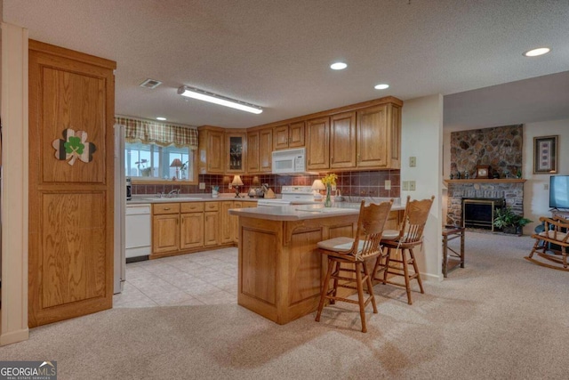 3131 Allison Ct Unit 3A, Young Harris, GA 30582 - kitchen featuring decorative backsplash, a breakfast bar, a peninsula, white appliances, and light colored carpet