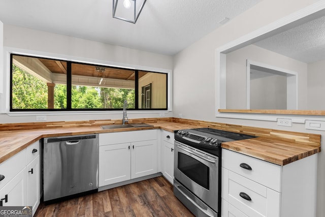 kitchen featuring dark wood-style floors, stainless steel appliances, a sink, and butcher block counters