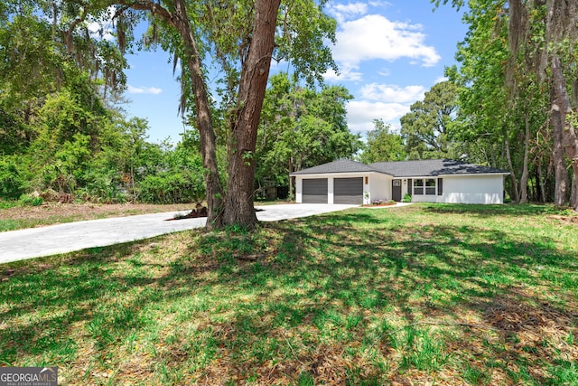 view of yard featuring driveway and an attached garage