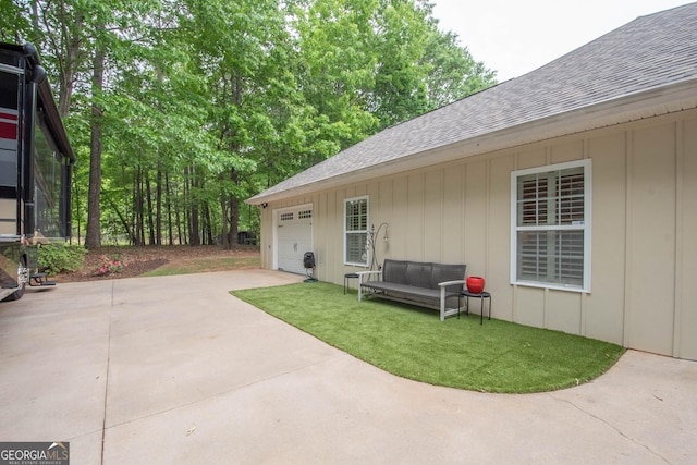 view of patio with concrete driveway and an attached garage