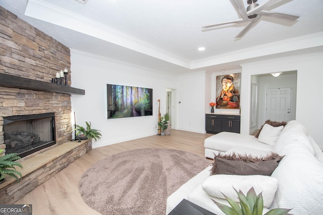 living room featuring crown molding, a raised ceiling, ceiling fan, and wood finished floors