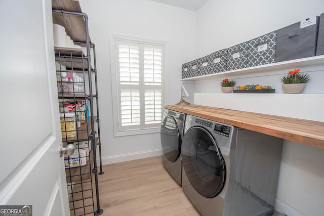 laundry room with plenty of natural light, light wood finished floors, laundry area, and washing machine and dryer