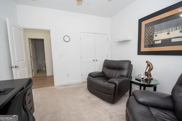 sitting room with ceiling fan, baseboards, and light carpet