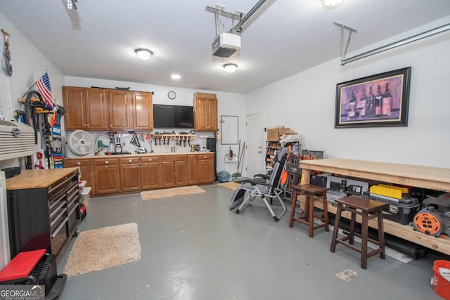 garage featuring a garage door opener and a workshop area