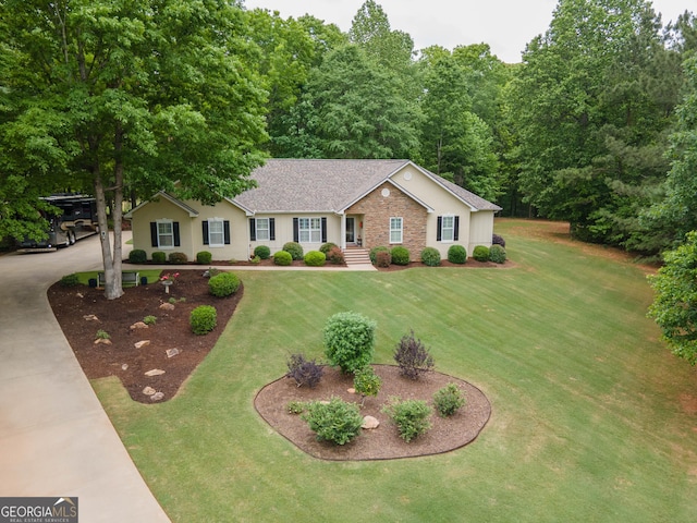 ranch-style house featuring roof with shingles and a front yard