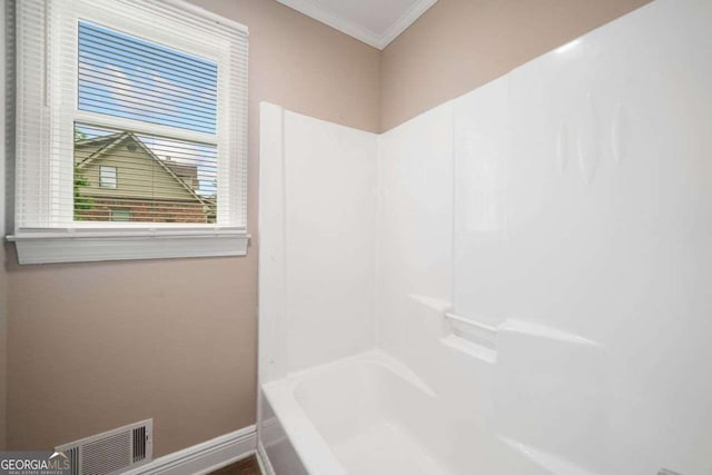 bathroom with visible vents, crown molding, and baseboards