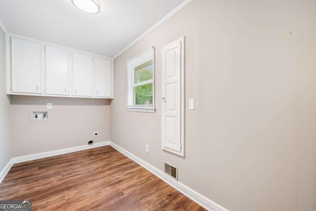 laundry area with washer hookup, visible vents, baseboards, cabinet space, and wood finished floors