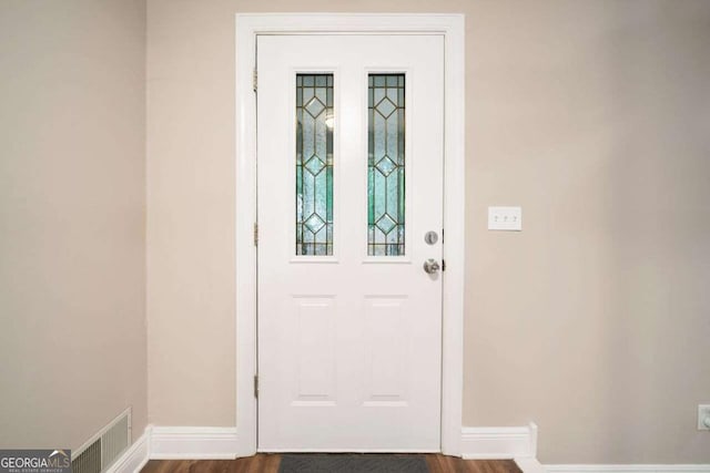 interior space with baseboards, visible vents, and dark wood-style flooring