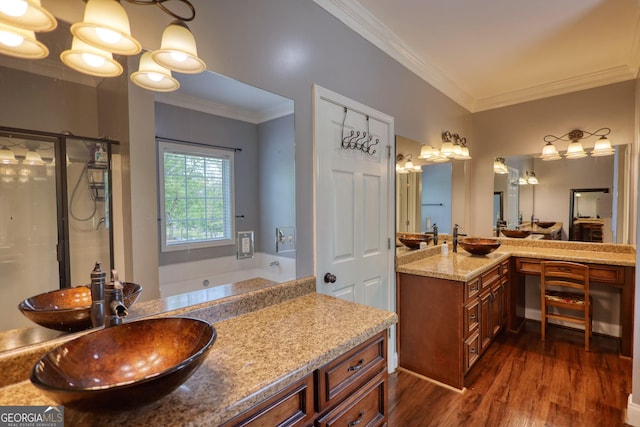 bathroom with crown molding, a bath, wood finished floors, and vanity