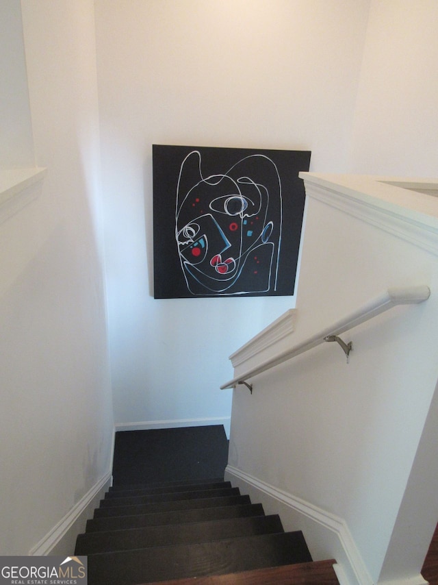 staircase featuring baseboards