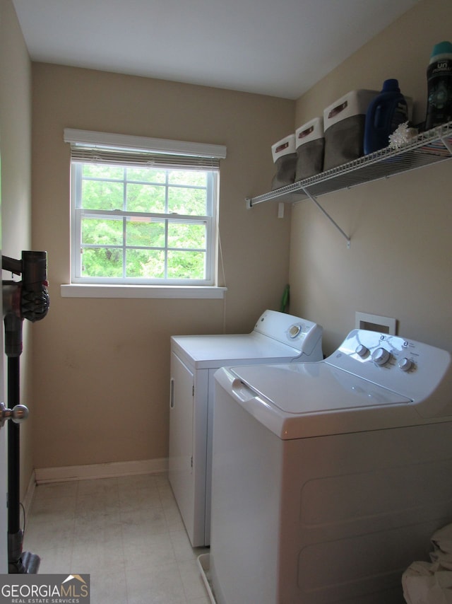 clothes washing area featuring washer and dryer, laundry area, and baseboards