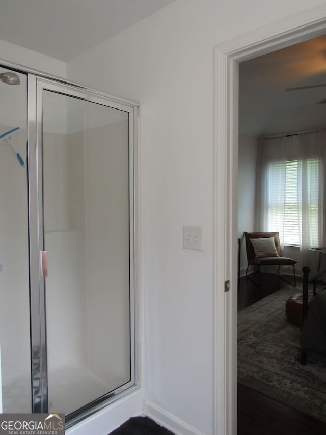 bathroom featuring a shower stall and wood finished floors