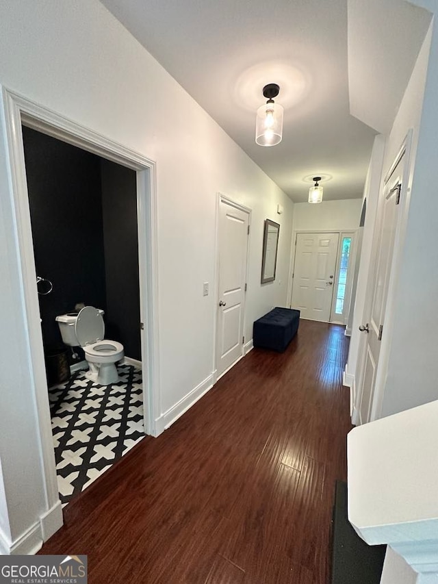 hallway featuring baseboards and wood finished floors