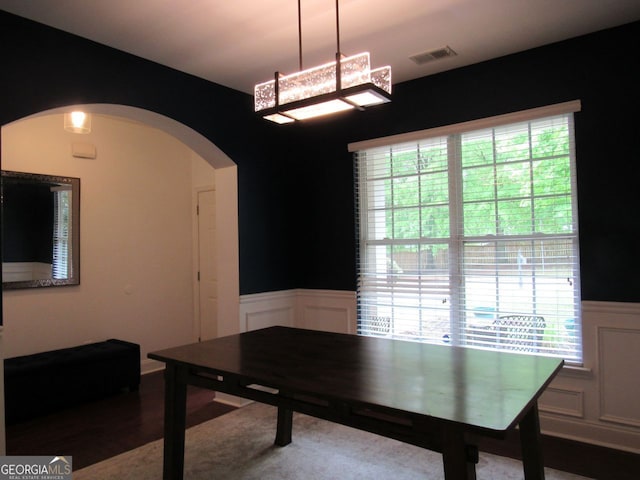 home office featuring arched walkways, a wainscoted wall, a decorative wall, and visible vents