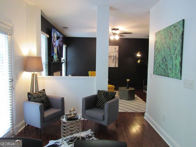 sitting room with baseboards, ceiling fan, wood finished floors, and visible vents
