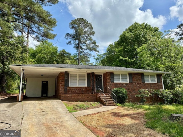 ranch-style house featuring brick siding, a carport, and driveway