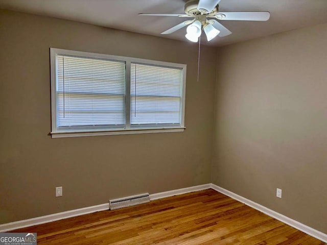 unfurnished room featuring wood finished floors, visible vents, ceiling fan, and a healthy amount of sunlight