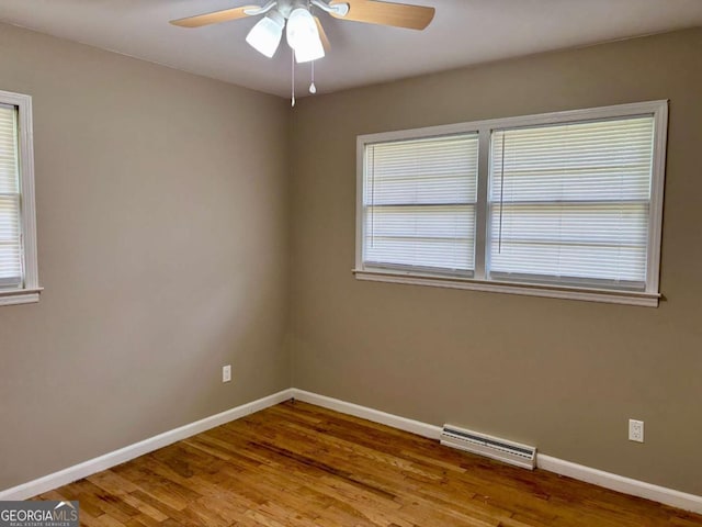 unfurnished room featuring baseboards, visible vents, and wood finished floors