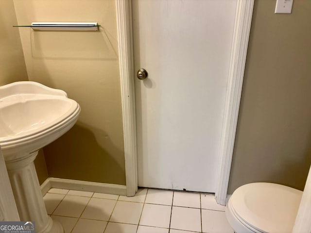 bathroom with toilet, tile patterned floors, and baseboards