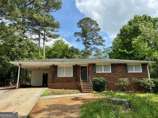 ranch-style home featuring brick siding, concrete driveway, and an attached carport