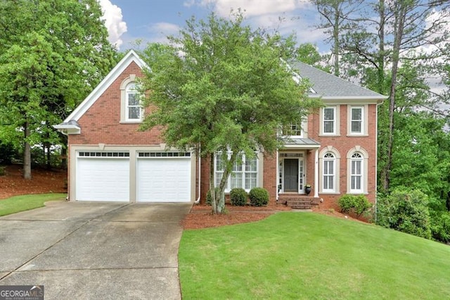colonial inspired home with an attached garage, a front lawn, brick siding, and concrete driveway