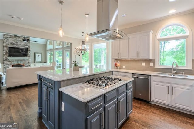 kitchen with open floor plan, white cabinets, island exhaust hood, a sink, and appliances with stainless steel finishes