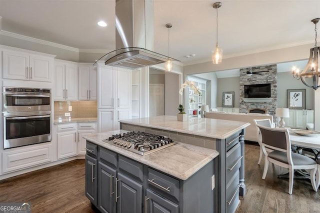 kitchen with white cabinets, a center island, stainless steel appliances, range hood, and gray cabinetry