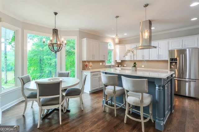 kitchen featuring island range hood, light countertops, stainless steel fridge with ice dispenser, a sink, and white cabinetry