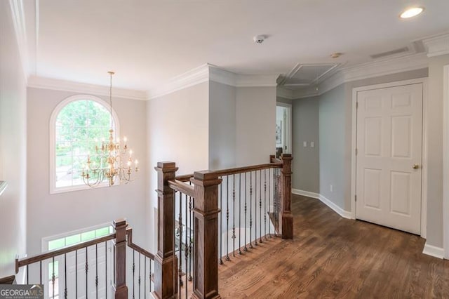 corridor with a notable chandelier, attic access, baseboards, an upstairs landing, and wood finished floors