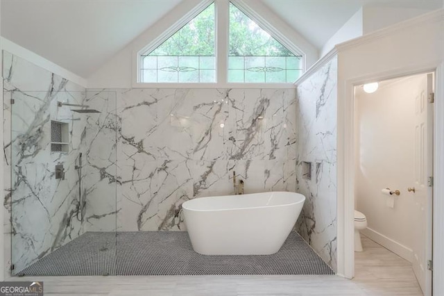 bathroom featuring a marble finish shower, vaulted ceiling, and toilet