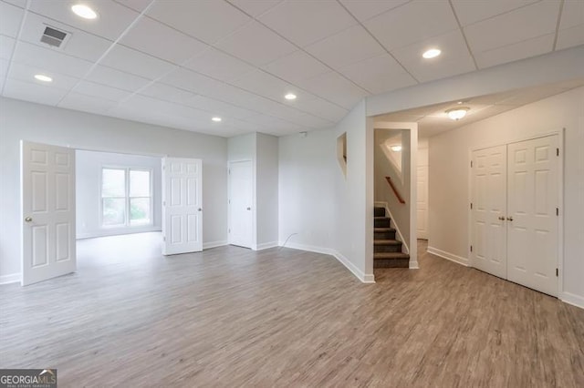 basement with visible vents, baseboards, wood finished floors, and stairway