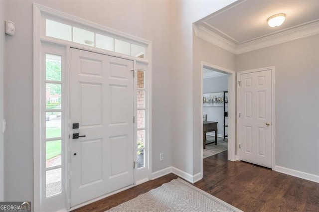 foyer featuring baseboards, ornamental molding, and dark wood-type flooring