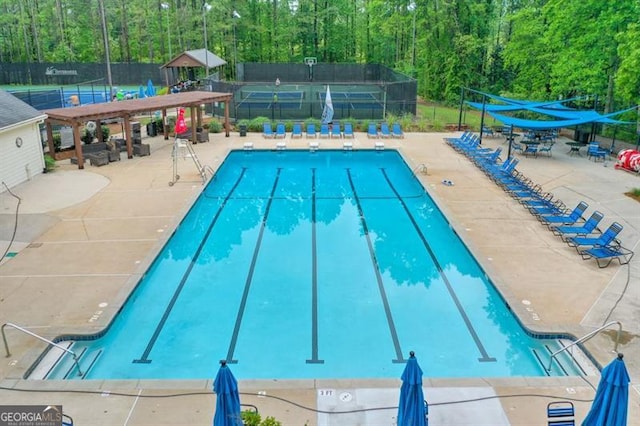 community pool featuring a patio area and fence