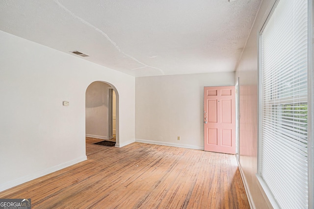 2447 Crestview Ave, Decatur, GA 30032 - empty room with arched walkways, light wood-type flooring, and baseboards