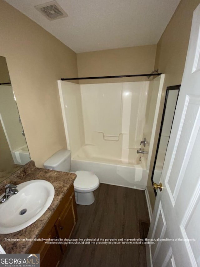 full bathroom with vanity, toilet, visible vents, shower / washtub combination, and wood finished floors