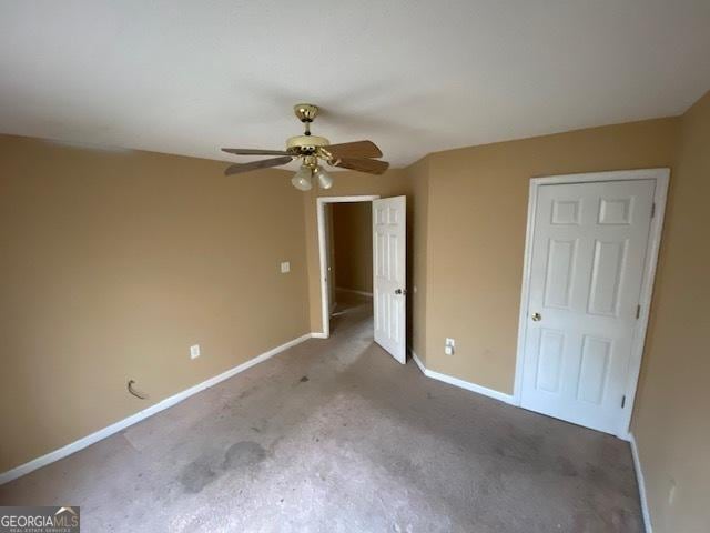 unfurnished bedroom with ceiling fan, carpet, and baseboards